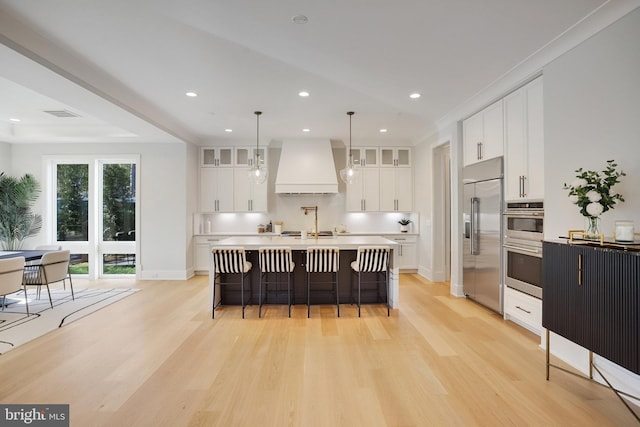 7013 Raleigh Rd, Annandale, VA 22003 - kitchen featuring light wood-type flooring, stainless steel appliances, light countertops, and custom range hood