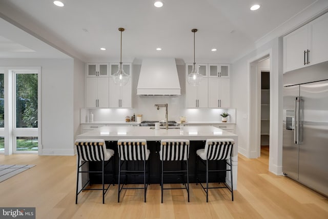 7013 Raleigh Rd, Annandale, VA 22003 - kitchen featuring premium range hood, built in refrigerator, baseboards, and light wood finished floors