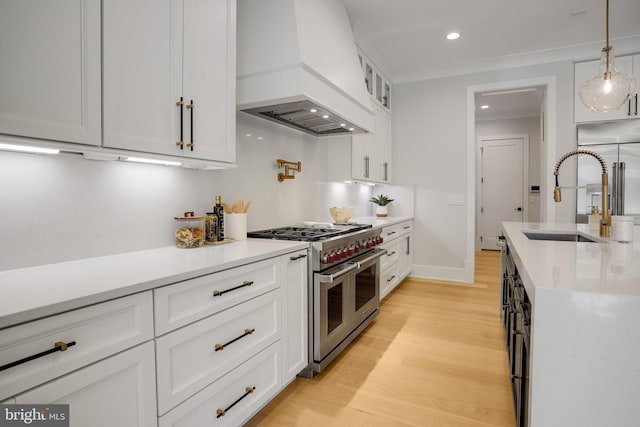 7013 Raleigh Rd, Annandale, VA 22003 - kitchen with custom exhaust hood, high quality appliances, a sink, light wood-style floors, and light countertops