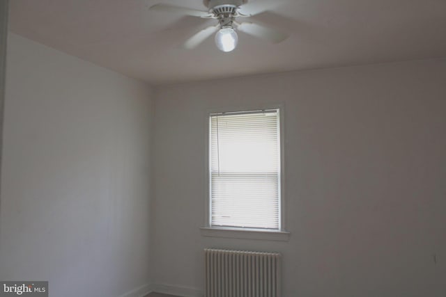 spare room featuring radiator and ceiling fan