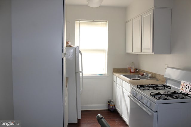 kitchen featuring white cabinets, dark hardwood / wood-style flooring, white appliances, and sink