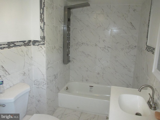 full bathroom with tiled shower / bath combo, toilet, sink, and tile walls