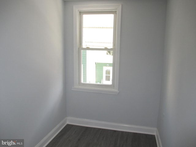 unfurnished room with dark wood-type flooring