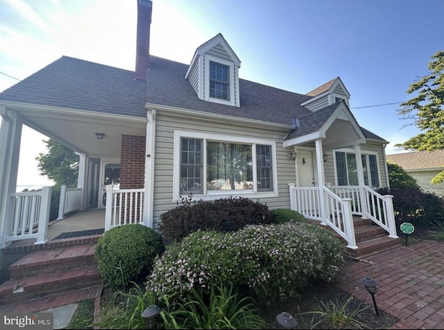 cape cod-style house featuring covered porch