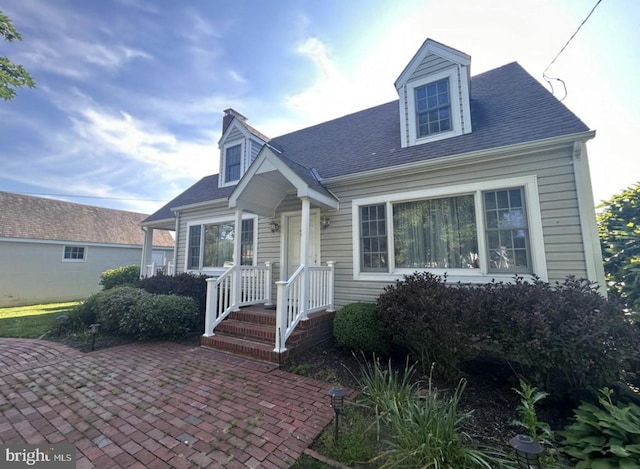 cape cod home featuring a patio