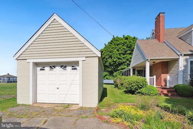 garage featuring a yard and a porch