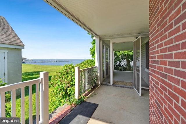 balcony with covered porch and a water view