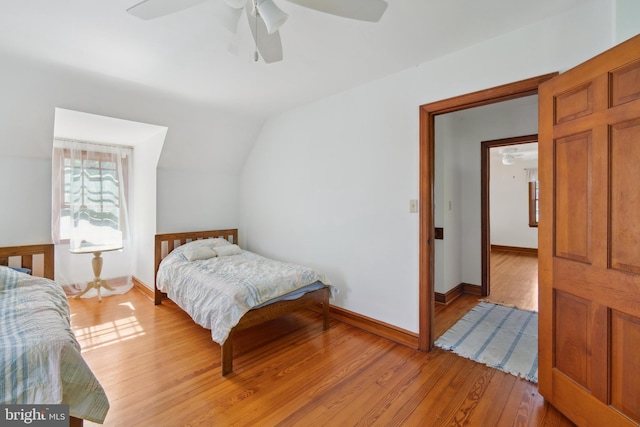 bedroom with ceiling fan, light hardwood / wood-style flooring, and lofted ceiling