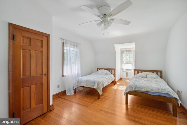 bedroom with light hardwood / wood-style floors, vaulted ceiling, and multiple windows