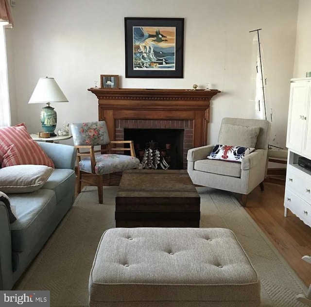 sitting room featuring light hardwood / wood-style floors and a brick fireplace