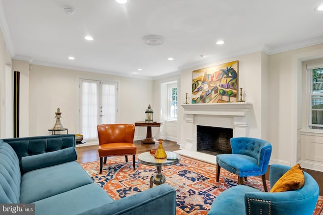 living room featuring hardwood / wood-style floors, a healthy amount of sunlight, ornamental molding, and french doors