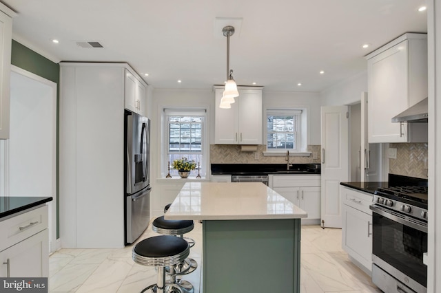 kitchen with stainless steel appliances, range hood, decorative light fixtures, decorative backsplash, and white cabinets