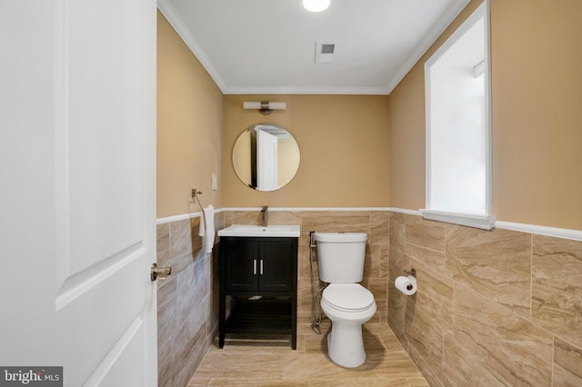 bathroom with vanity, toilet, tile walls, and crown molding