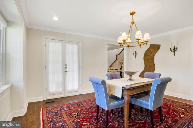 dining room with a chandelier, french doors, dark hardwood / wood-style floors, and crown molding