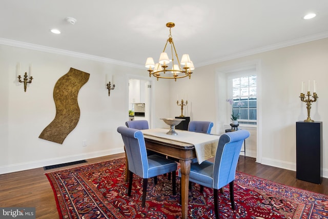 dining room featuring a notable chandelier, dark hardwood / wood-style floors, and crown molding