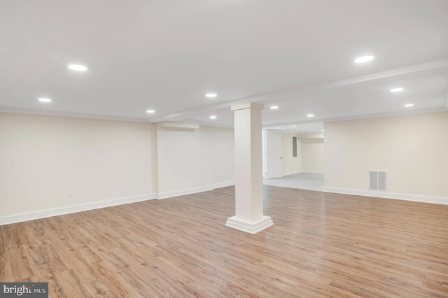 basement featuring crown molding and light hardwood / wood-style floors