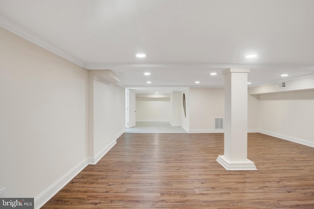 basement with light wood-type flooring and ornamental molding