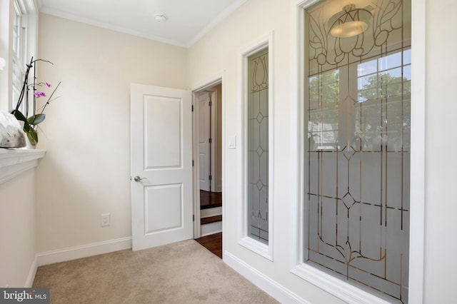 corridor featuring ornamental molding and light carpet