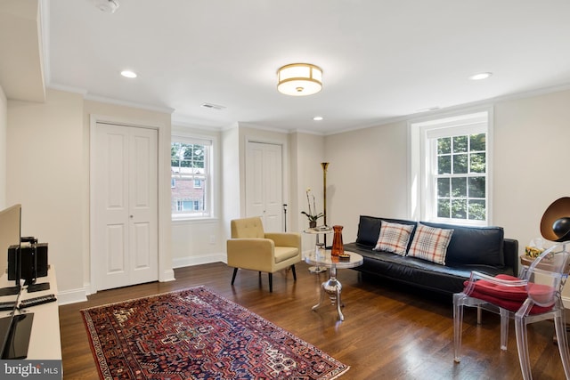 living room with dark hardwood / wood-style flooring and crown molding