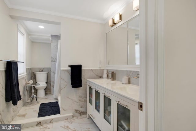 bathroom with walk in shower, crown molding, toilet, vanity, and tile walls