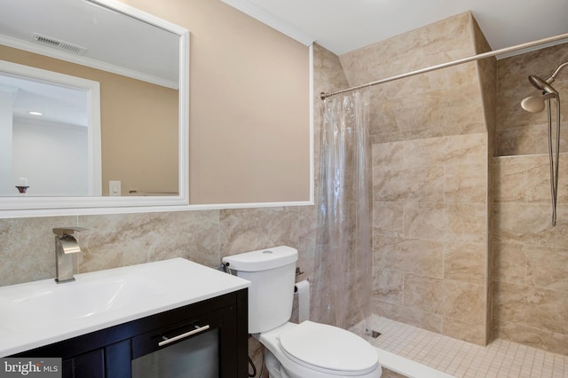 bathroom featuring walk in shower, crown molding, toilet, vanity, and tile walls