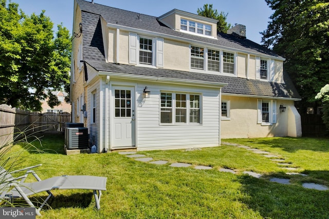 back of house featuring a yard and central air condition unit