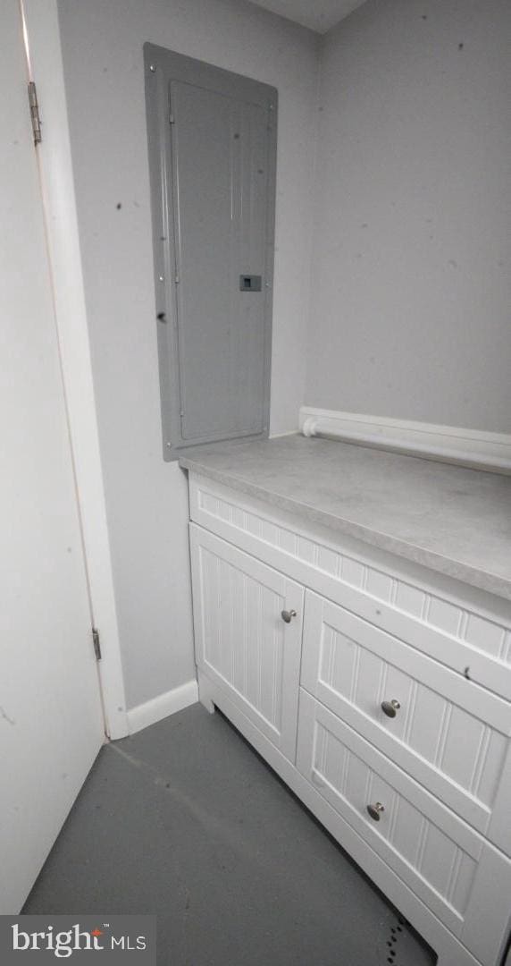 bathroom featuring electric panel and concrete flooring