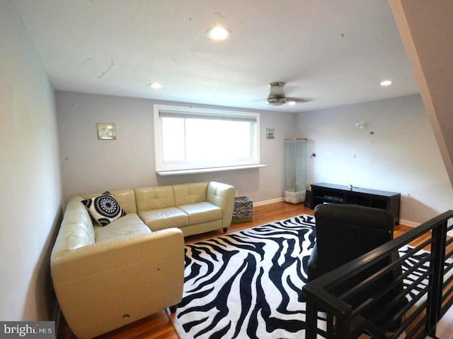 living room featuring hardwood / wood-style floors and ceiling fan