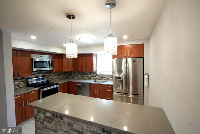 kitchen featuring decorative light fixtures, backsplash, stainless steel appliances, and sink