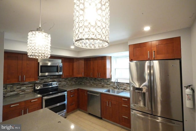 kitchen featuring sink, decorative light fixtures, appliances with stainless steel finishes, tasteful backsplash, and a notable chandelier