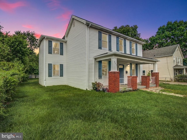 view of front of house with covered porch and a lawn