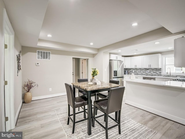 dining space featuring light hardwood / wood-style floors and sink