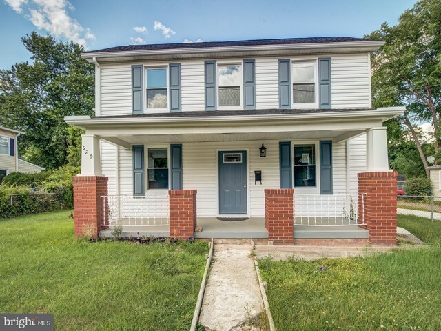 view of front facade with a front yard and covered porch