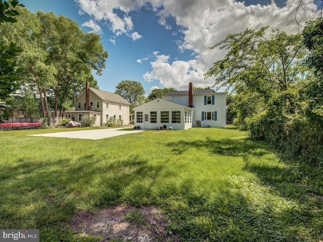 rear view of property with a lawn