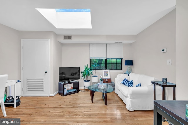 living room featuring a skylight and light hardwood / wood-style floors