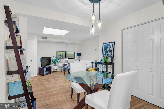 dining area featuring a skylight and light hardwood / wood-style floors