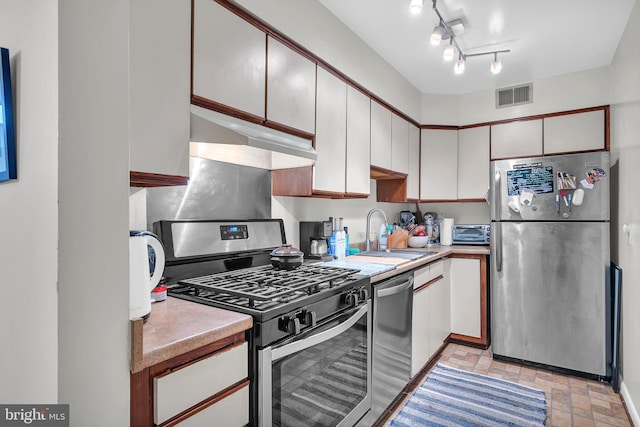 kitchen featuring sink, white cabinets, and stainless steel appliances