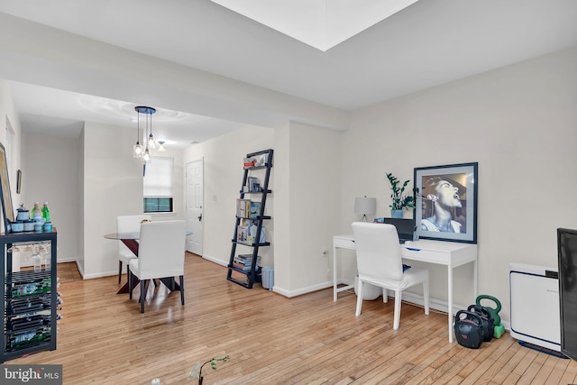 office featuring wine cooler, light hardwood / wood-style flooring, and a notable chandelier