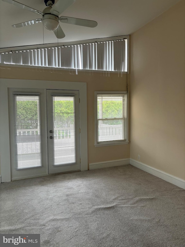 carpeted spare room featuring french doors and ceiling fan