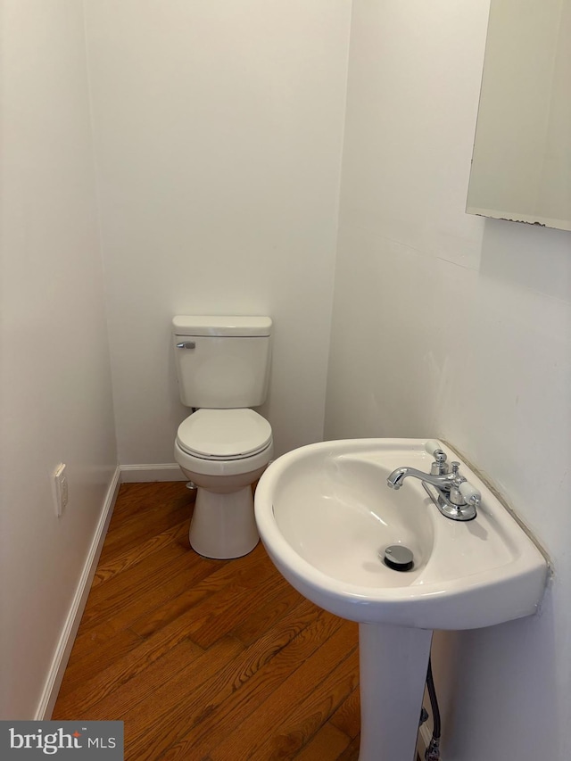 bathroom with toilet and hardwood / wood-style flooring