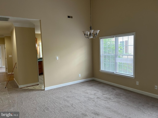 carpeted spare room featuring a notable chandelier, a towering ceiling, and crown molding