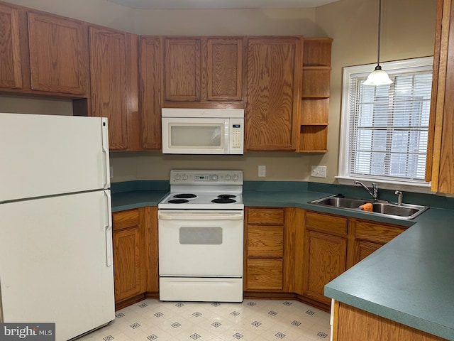 kitchen with sink, pendant lighting, and white appliances