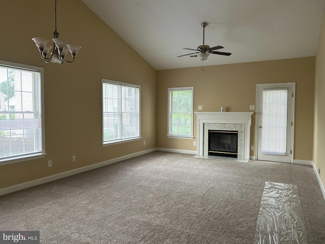 unfurnished living room with a high end fireplace, light carpet, ceiling fan with notable chandelier, and high vaulted ceiling