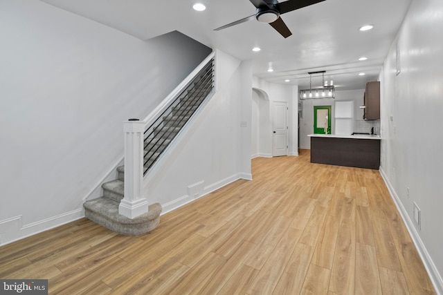 unfurnished living room featuring ceiling fan and light hardwood / wood-style floors