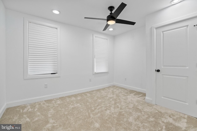 carpeted spare room with ceiling fan