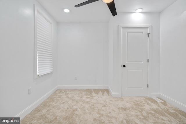 carpeted spare room with ceiling fan