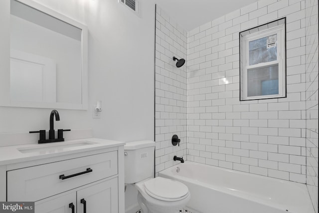 full bathroom featuring tiled shower / bath combo, toilet, and vanity