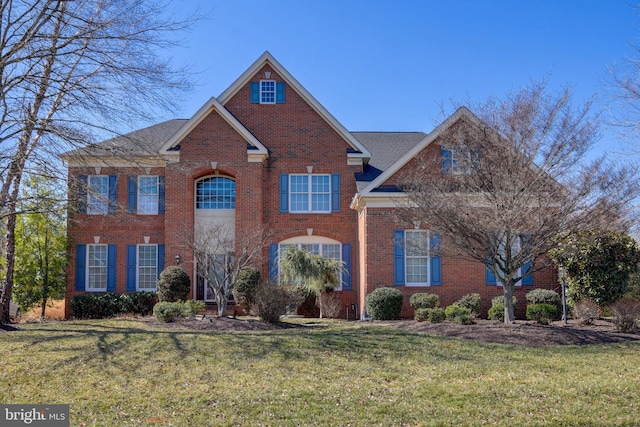 view of front of home featuring a front yard and brick siding