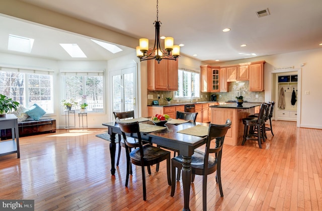 dining area featuring light wood-type flooring, visible vents, recessed lighting, baseboards, and a chandelier