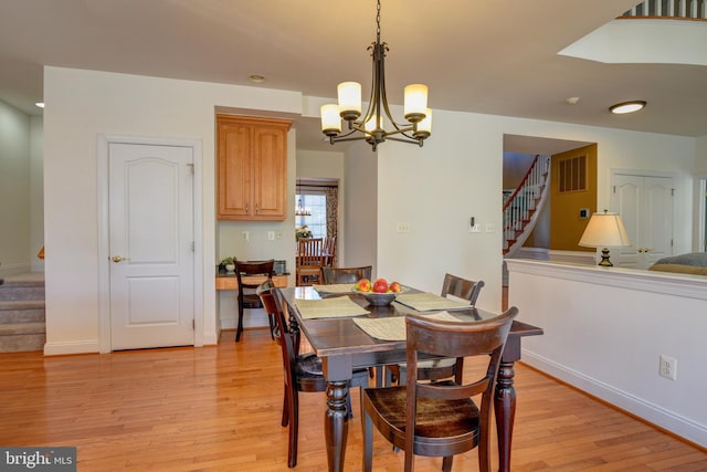 dining area featuring stairway, baseboards, visible vents, and light wood-style flooring